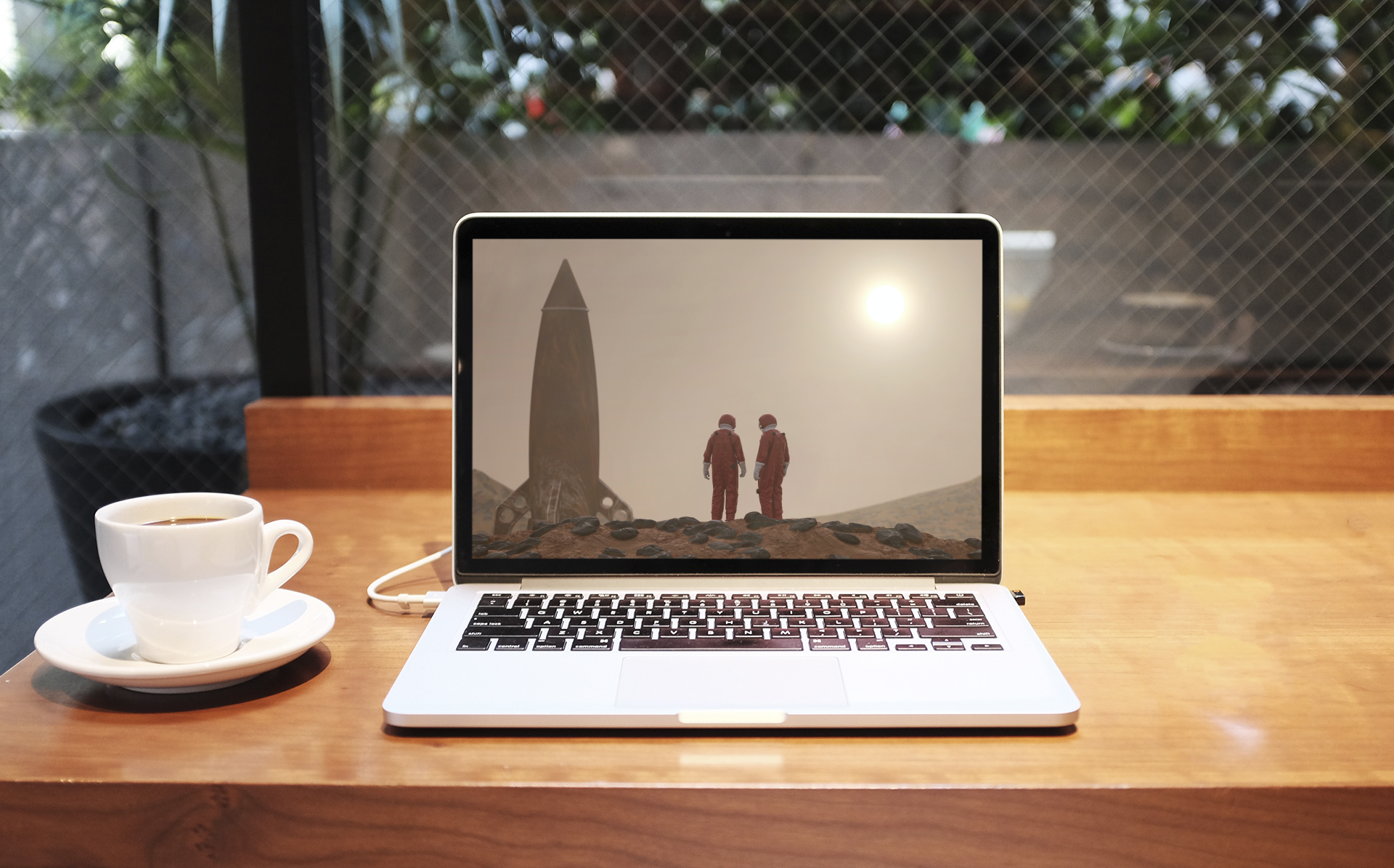 An open laptop sits to the right of a coffee cup.